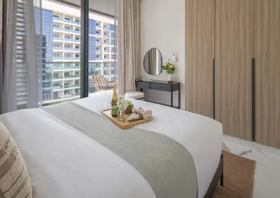 a bedroom with a large white bed with a window at Frank Poretr - The Pinnacle, Dubai Hills in Dubai