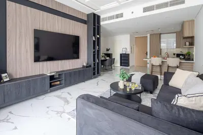 a living room with a couch and a tv on a wall at Frank Poretr - The Pinnacle, Dubai Hills in Dubai