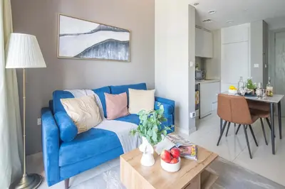 a living room with a blue couch and a table at Frank Porter - Zada Tower in Dubai