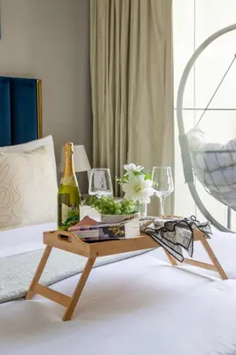 a table with a bottle of wine and glasses on a bed at Frank Porter - Zada Tower in Dubai