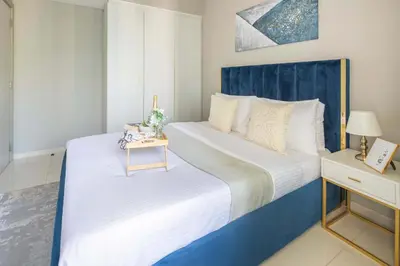 a bedroom with two beds with a blue headboard at Frank Porter - Zada Tower in Dubai