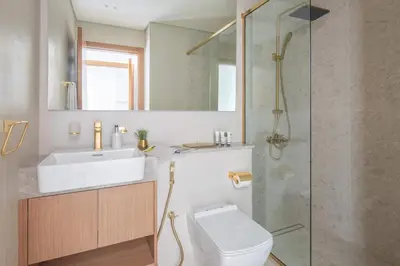 a bathroom with a toilet and a sink and a shower at Frank Porter - Binghatti Amber in Dubai