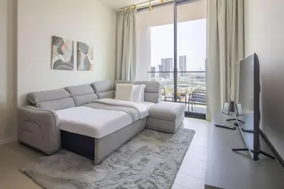 a living room with a couch and a tv at Frank Porter - Binghatti Amber in Dubai