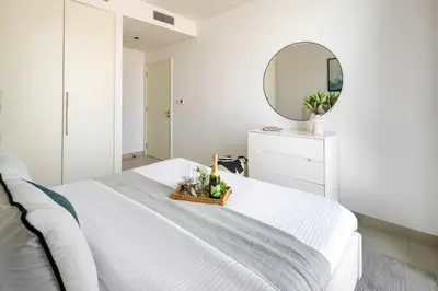 a white bedroom with a white bed and a mirror at Frank Porter - Burj Crown in Dubai