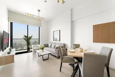 a living room with a table and a couch at VayK - Cozy Stylish 1BR in JVC in Dubai