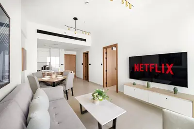 a living room with a television on a wall at VayK - Cozy Stylish 1BR in JVC in Dubai
