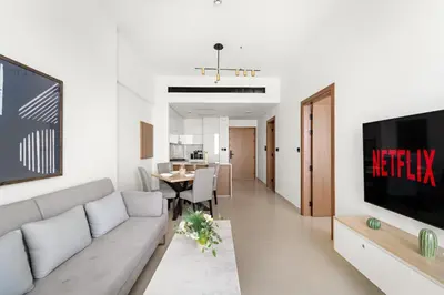 a living room with a couch and a tv at VayK - Cozy Stylish 1BR in JVC in Dubai