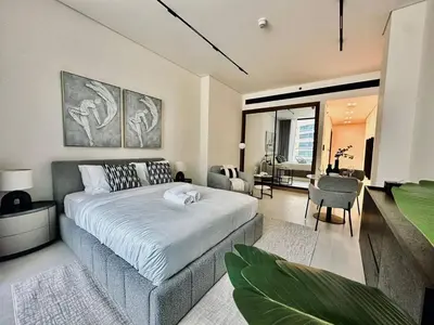 a bedroom with a large bed and a living room at Artful Canal Escape With Jacuzzi And City Views! in Dubai