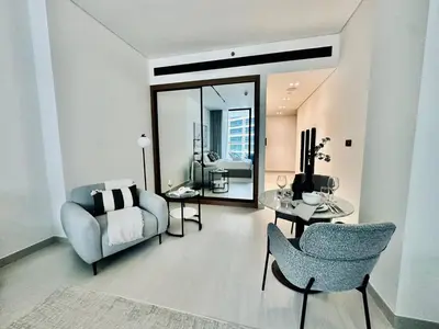 a living room with a couch and a chair at Artful Canal Escape With Jacuzzi And City Views! in Dubai