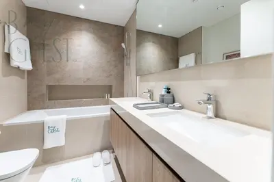 a bathroom with a large white sink and a tub at Spice of Sophistication in a 2BR Downtown Views II in Dubai