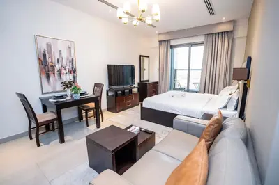 a hotel room with a bed and a living room at Elite Haven, Elegant Escape in Dubai - Free Pool in Dubai