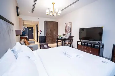 a bedroom with a white bed and a living room at Elite Haven, Elegant Escape in Dubai - Free Pool in Dubai