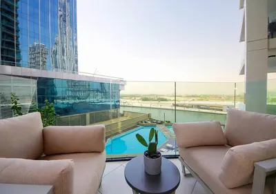 a living room with a pool in a building at Urban Oasis 2BR Retreat in Dubai with Pool View in Dubai