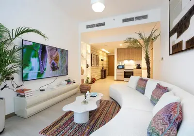 a living room with a white couch and a tv at Urban Oasis 2BR Retreat in Dubai with Pool View in Dubai