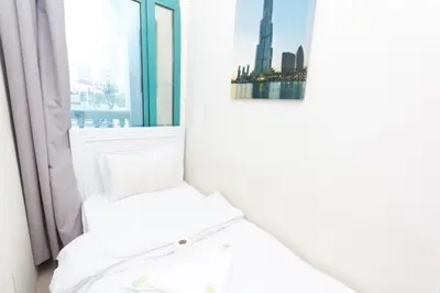 a white room with a window and a chair at Must update to luxury studio in heart of marina Dubai in Dubai