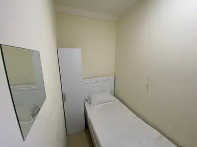 a small white room with a bed and a mirror at Must update to luxury studio in heart of marina Dubai in Dubai