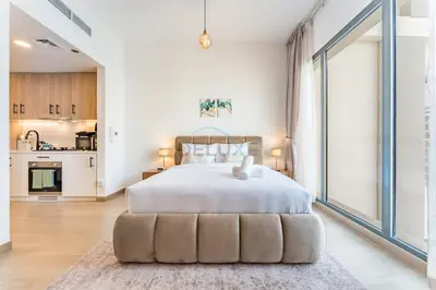 a bedroom with a large bed with a large window at Steps Away from Town Square Park Studio, Minutes Drive to Butterfly Garden, Liva Apartments, Town Square by Deluxe Holiday Homes in Dubai