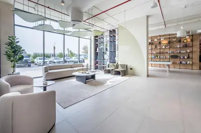 a living room with couches and tables and windows at Steps Away from Town Square Park Studio, Minutes Drive to Butterfly Garden, Liva Apartments, Town Square by Deluxe Holiday Homes in Dubai