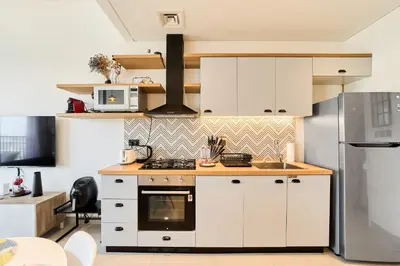 a kitchen with white cabinets and a stove at Chic 1BR With Balcony in Collective 2 Dubai Hills in Dubai