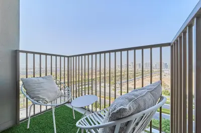 a balcony with two chairs and a table at Chic 1BR With Balcony in Collective 2 Dubai Hills in Dubai