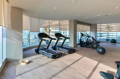 a gym with treadmills and ellipticals in a building at LUXE Rooftop Infinity Pool 5 Mins to JBR Dubai Marina View in Dubai