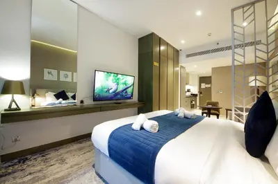 a hotel room with a large bed and a flat screen tv at Stylish Damac Prive Studio on hghFlr with Canal View in Dubai
