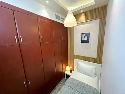 a small bedroom with a bed and wooden cabinets at Retreat One Room In Tecom Barsha Heights in Dubai