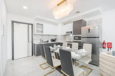 a kitchen and dining room with a table and chairs at StayShort - Beautiful Al Furjan 2 bed apartment for 4 people in Dubai