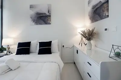 a white bedroom with a bed and a desk at 2BR I Aykon City I Business Bay I Bshh in Dubai