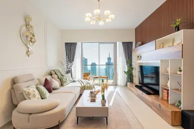 a living room with a couch and a tv at Grande Signature Residence by Hogar in Dubai