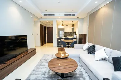 a living room with a white couch and a table at High-Rise Comfort 2BR in Nobles Tower in Dubai in Dubai