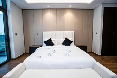 a bedroom with a large bed with white sheets at High-Rise Comfort 2BR in Nobles Tower in Dubai in Dubai