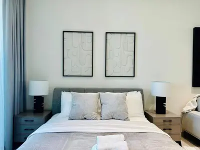 a bedroom with two pictures on the wall above a bed at Luxe Studio Retreat Jacuzzi Parking, Pool & Gym in Dubai
