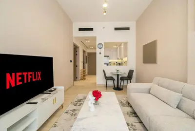 a living room with a couch and a tv at Stylish 1BR Apartment in Binghatti Luna JVC Dubai in Dubai