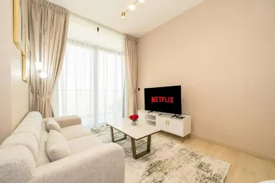 a living room with a white couch and a tv at Stylish 1BR Apartment in Binghatti Luna JVC Dubai in Dubai