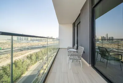 a balcony with chairs and windows in a building at Stylish 1BR Apartment in Binghatti Luna JVC Dubai in Dubai