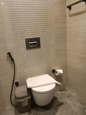 a bathroom with a toilet in a tiled wall at Modern 2BR Apartment Nobles Tower Dubai Views in Dubai