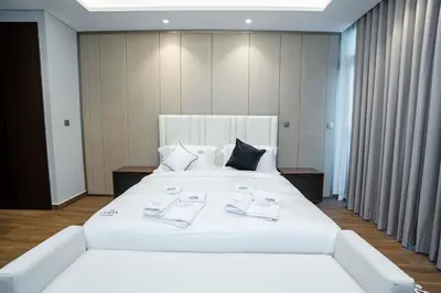 a large white bed in a hotel room at Modern 2BR Apartment Nobles Tower Dubai Views in Dubai