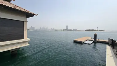 a large body of water with a building and a dock at Stunning 1BR at Anantara Sea Views Palm Jumeirah in Dubai