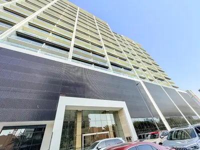a large building with cars parked in a parking lot at Luxury 1BR Apt Binghatti Amber Prime Location in Dubai
