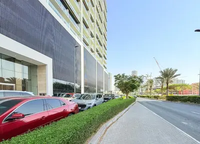 a row of cars parked in front of a building at Stylish Comfort Modern 1BR Apt Prime Location JVC in Dubai
