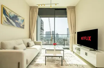 a living room with a white couch and a tv at Stylish Comfort Modern 1BR Apt Prime Location JVC in Dubai