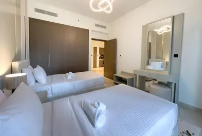 a bedroom with two beds with white sheets and a mirror at Elegant Style Brand new 2BDR in Heart of Downtown in Dubai