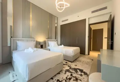 a hotel room with two beds and a chandelier at Elegant Style Brand new 2BDR in Heart of Downtown in Dubai
