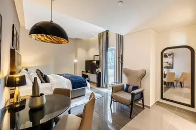 a bedroom with a bed and a dining room at Stylish Studio With Pool View Mins to Dubai Mall in Dubai