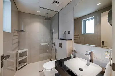 a white bathroom with a sink and a toilet at Stylish Studio With Pool View Mins to Dubai Mall in Dubai
