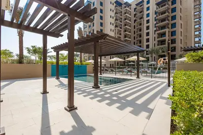 a pavilion with a pool in a city with buildings at Stylish Studio With Pool View Mins to Dubai Mall in Dubai