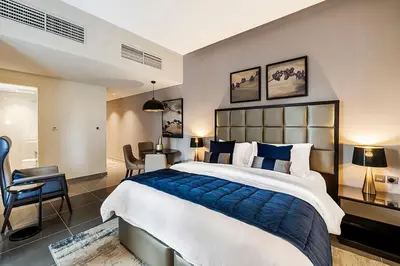 a bedroom with a large bed and a table and chairs at Stylish Studio With Pool View Mins to Dubai Mall in Dubai