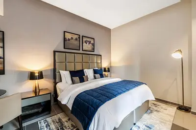 a bedroom with a blue and white bed and a desk at Stylish Studio With Pool View Mins to Dubai Mall in Dubai