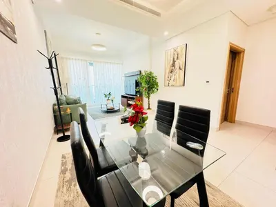 a dining room with a glass table and black chairs at Luxury 1BR The Bay Scenic Canal Creek Outlook in Dubai